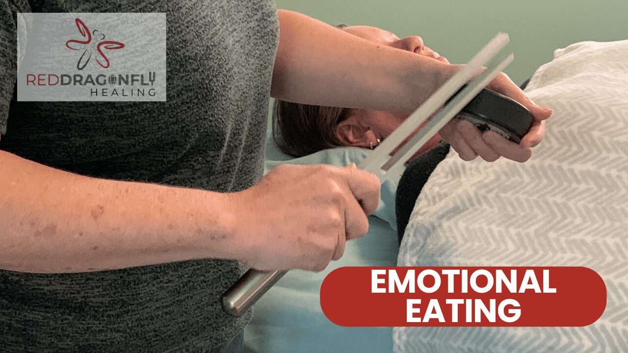 A person holds tuning forks over someone lying down, suggesting a healing session. The text EMOTIONAL EATING is overlaid, with the Red Dragonfly Healing logo in the top left.
