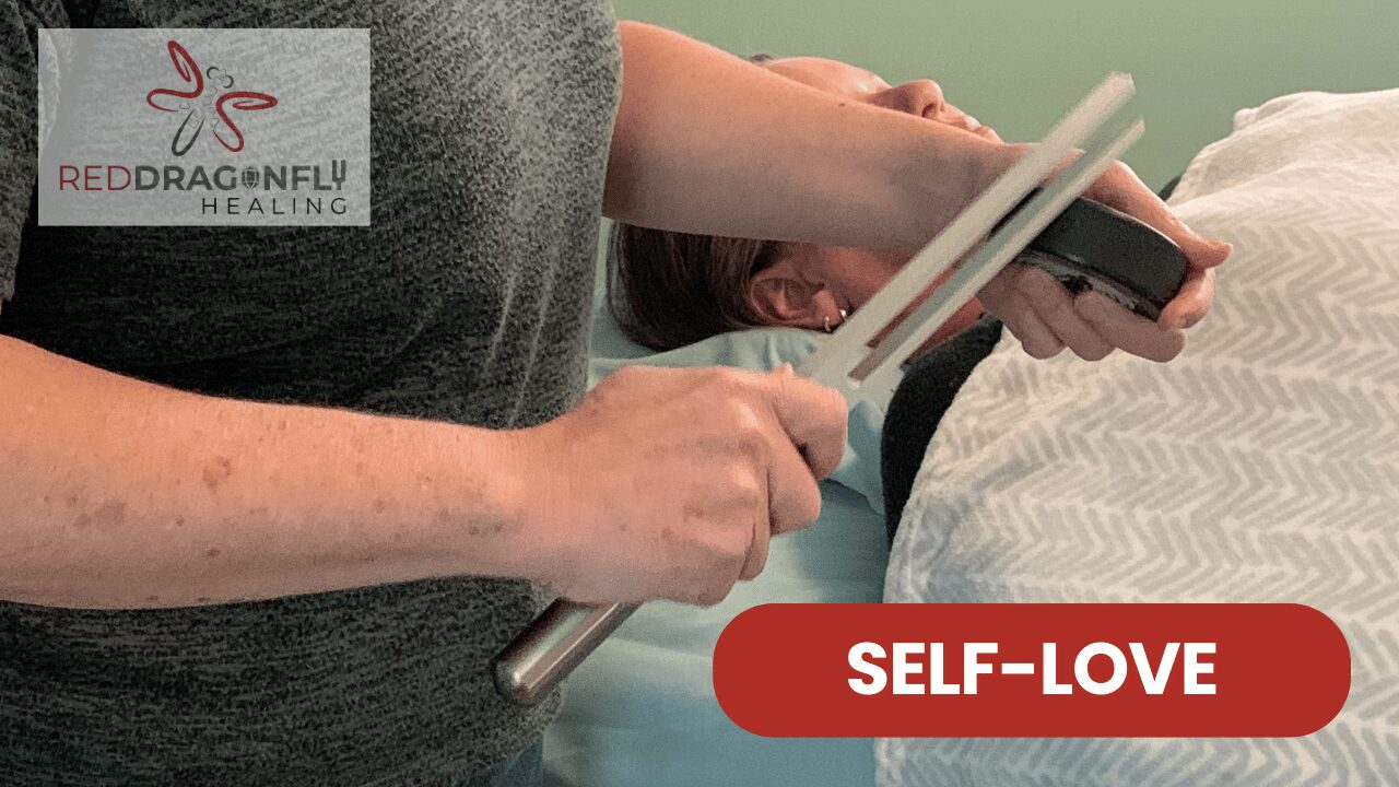 A person holds tuning forks above another person lying down, suggesting a sound healing session. The text REDDRAGONFLY HEALING and SELF-LOVE are displayed on the image.